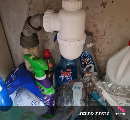 צינור ניקוז לבן מתחת לכיור עם חיבורים